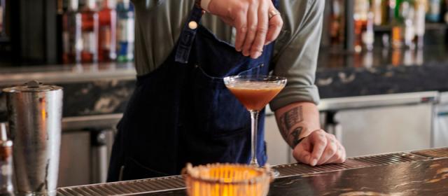 Bartender adding a garnish to a cocktail